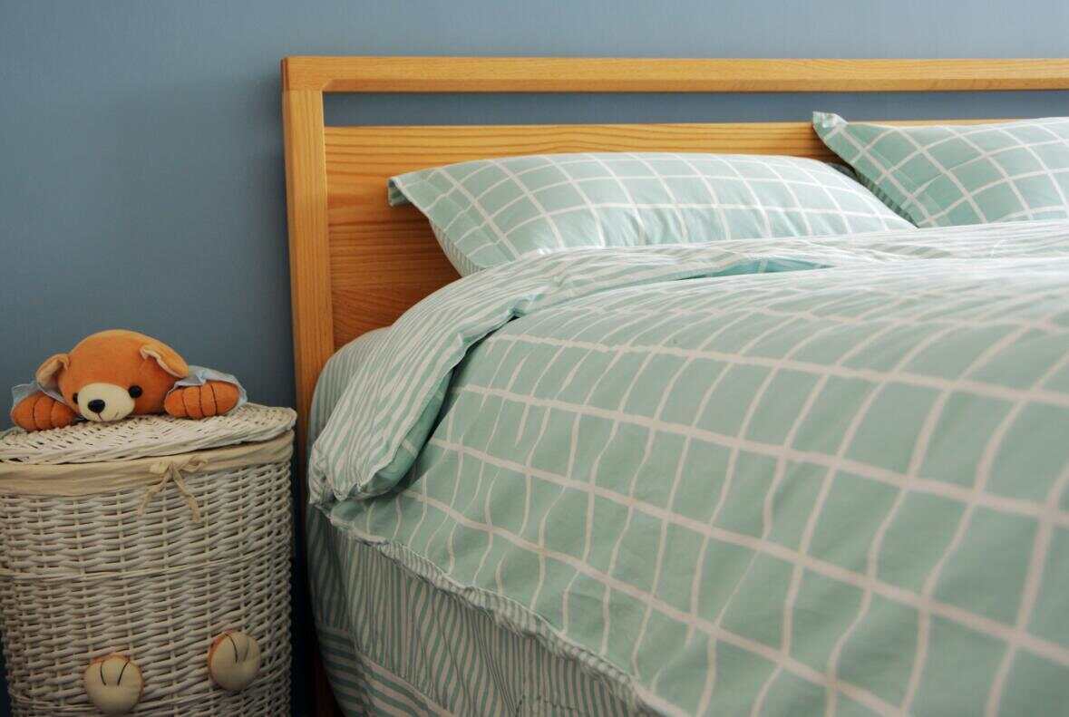 浅绿色的床品搭配原木色的家具非常清新，编织收纳篮更添休闲气息