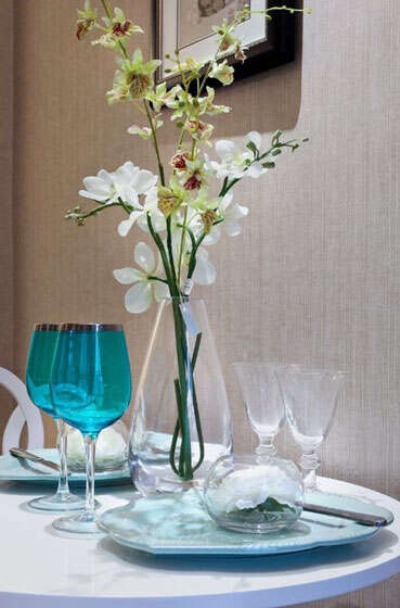 透明玻璃材质的花瓶，花开正盛、搭配着土灰色的壁纸